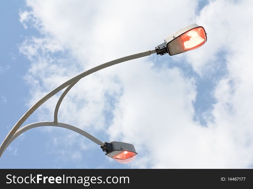 Shining street lamp over blue sky (Power savings concept)