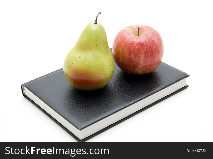 Apple and pear on black book. Apple and pear on black book