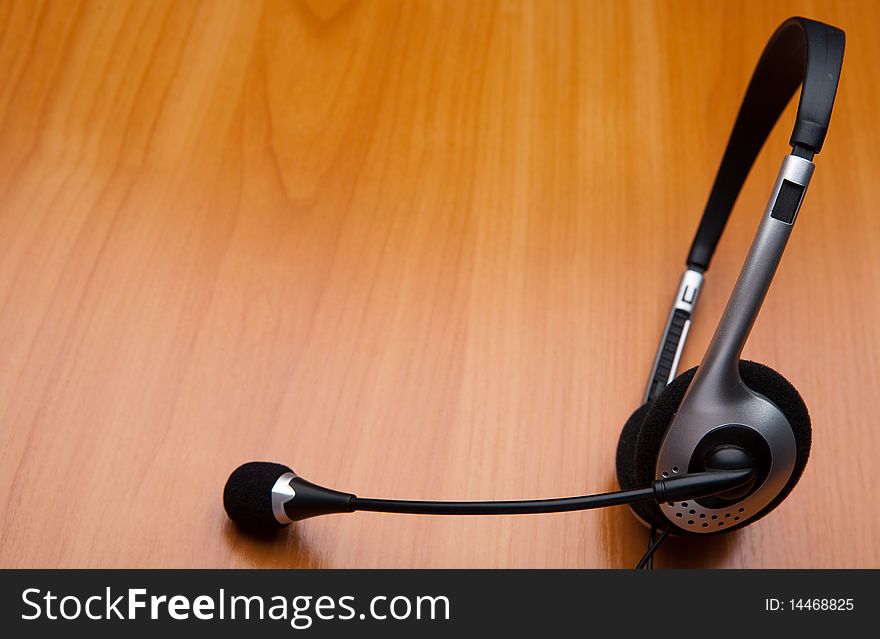 Headset over wooden table background