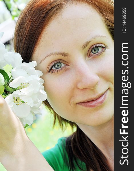 Young  woman standing at apple tree in white blossom. Young  woman standing at apple tree in white blossom