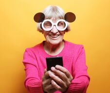 Free Old Grandmother Is Talking To Her Grandchildren By Phone, Smiling And Greeting Them. Royalty Free Stock Photo - 144630885