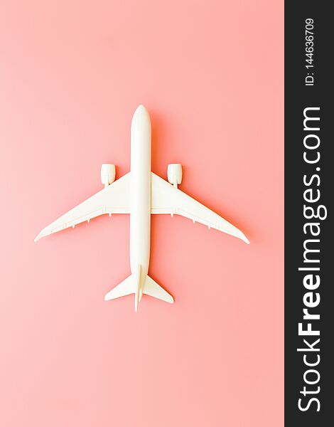 Model plane, airplane on pink pastel color background with copy space.Flat lay design.Travel concept on pink background. top view