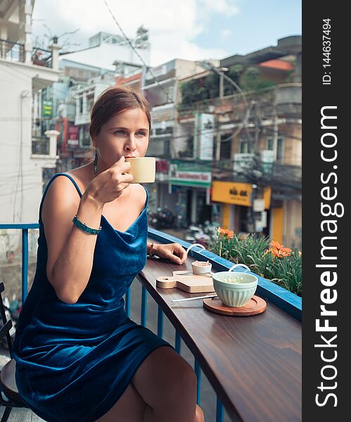 Beautiful Woman Sitting On Cafe Terrace. Panoramic Street View Of Da Lat City, Little Paris Of Vietnam