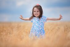 Happy Girl Walking In Golden Wheat, Enjoying The Life In The Field. Nature Beauty, Blue Sky And Field Of Wheat. Family Outdoor Stock Photo