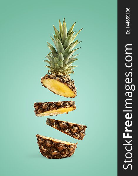 Pineapple Sliced, Levitates In The Air. Concept Of Summer Mood On A Green Background