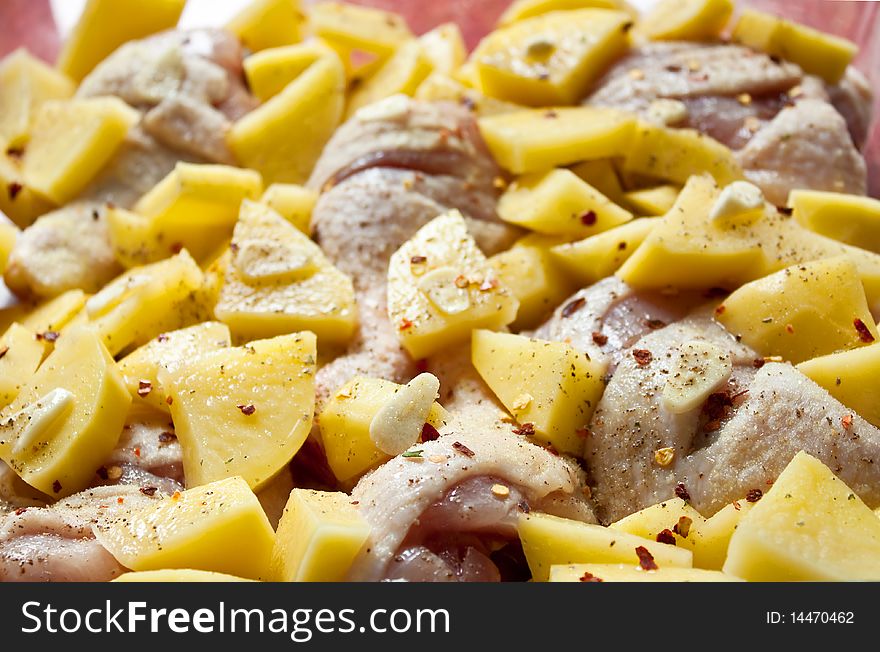 Chicken and chopped raw potatoes in a tray before the oven. Chicken and chopped raw potatoes in a tray before the oven