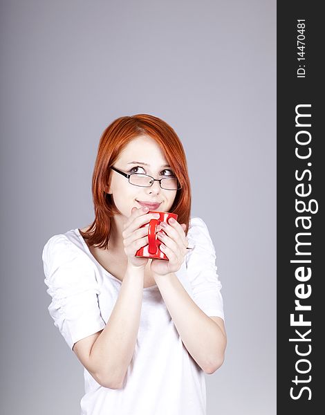 Red-haired businesswoman keep red cup in hand.