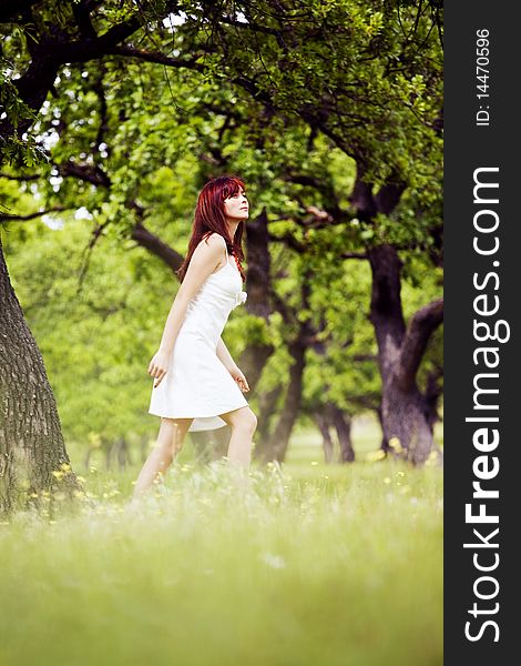 Beautiful woman in white walking through the green forest in summer. Beautiful woman in white walking through the green forest in summer