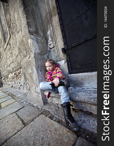 Girl sitting on steps on old wall background
