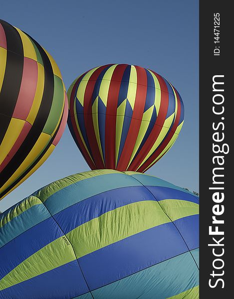 Partially inflated hot air balloons on the ground at the Blossom Time Festival in Chagrin Falls, Ohio. Vertical shot.