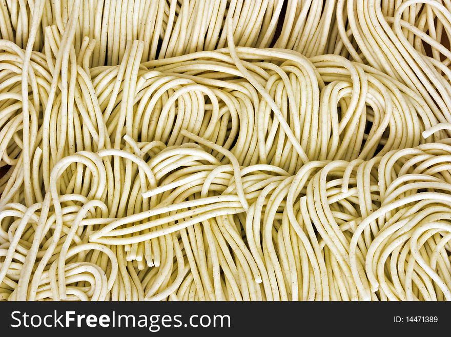 A macro picture of dried noodles on a wooden table. A macro picture of dried noodles on a wooden table