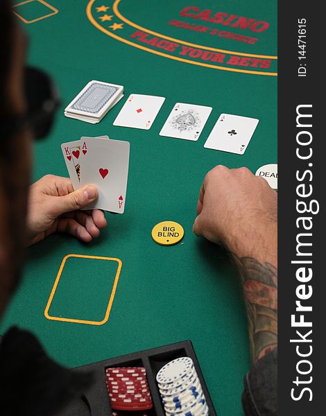 The model is playing poker and his hand reveals 4 of a kind aces.