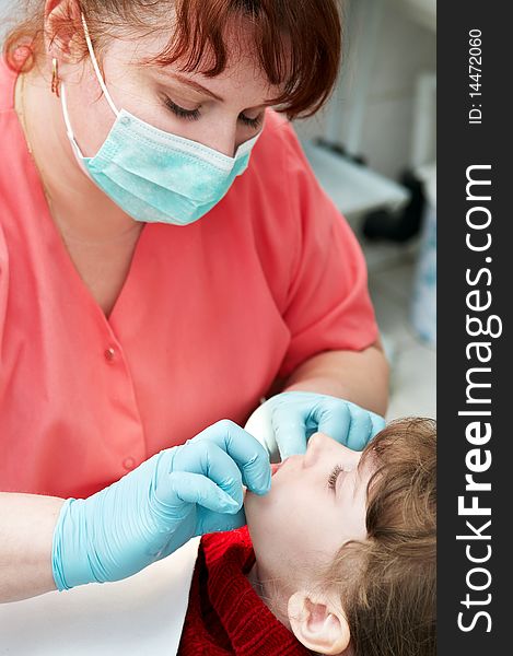 Orthodontic doctor examine teeth and gums of little girl jaw. Orthodontic doctor examine teeth and gums of little girl jaw