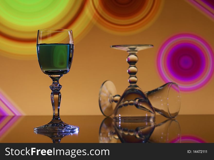 Green liqueur in wine glass on colorful abstract background. Green liqueur in wine glass on colorful abstract background