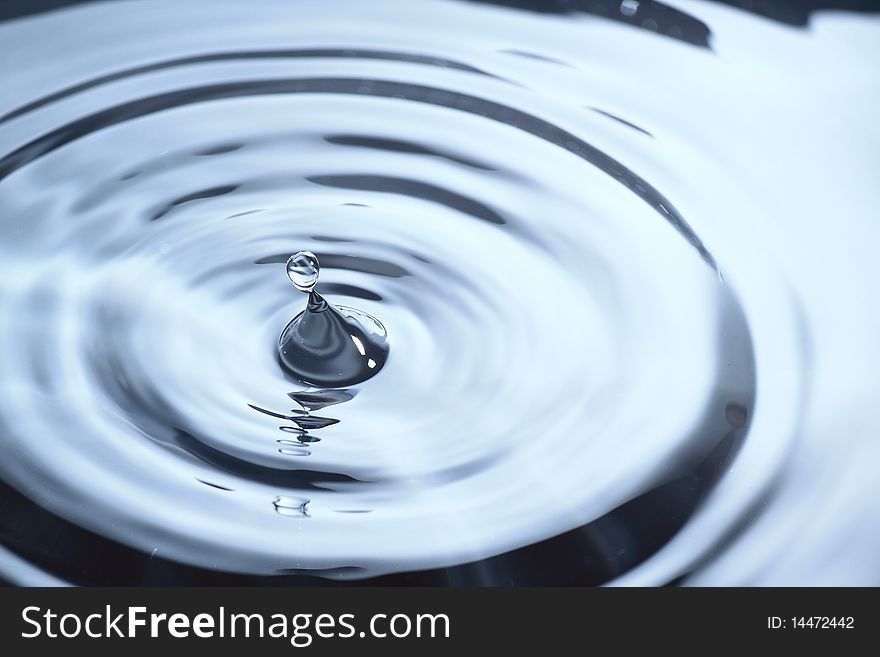 The round transparent drop of water, falls downwards