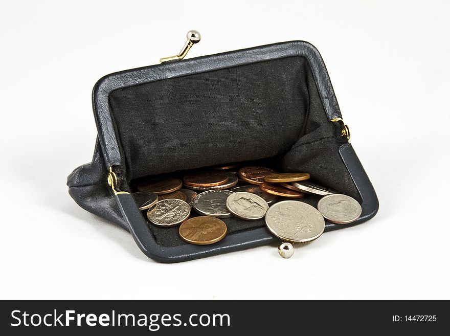 Open navy blue coin purse with lots of US coins on isolated white background. Open navy blue coin purse with lots of US coins on isolated white background