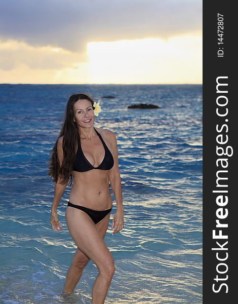 Beautiful forty year old woman at the beach in hawaii at sunrise. Beautiful forty year old woman at the beach in hawaii at sunrise