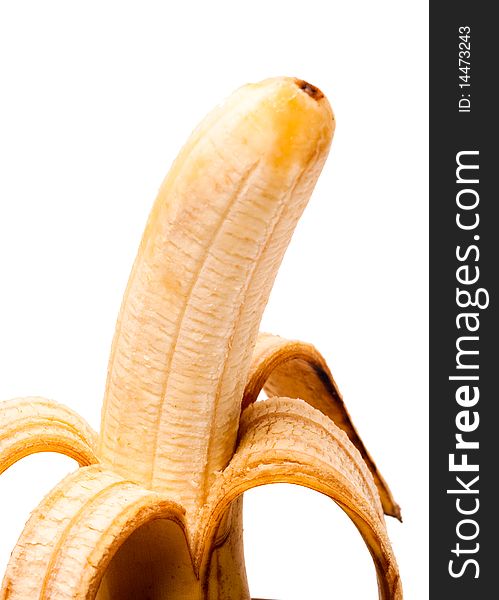 One banana with the removed peel, a close up. It is isolated