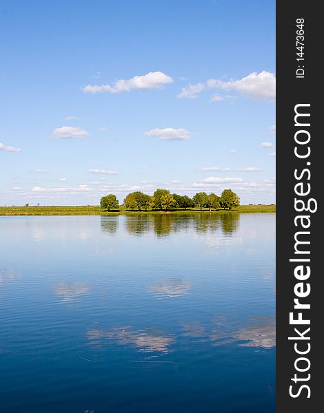 Beautiful river and yellow meadow under the summer sky