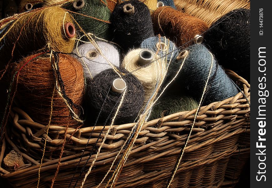 Colored wool threads in wooden vintage basket. Colored wool threads in wooden vintage basket