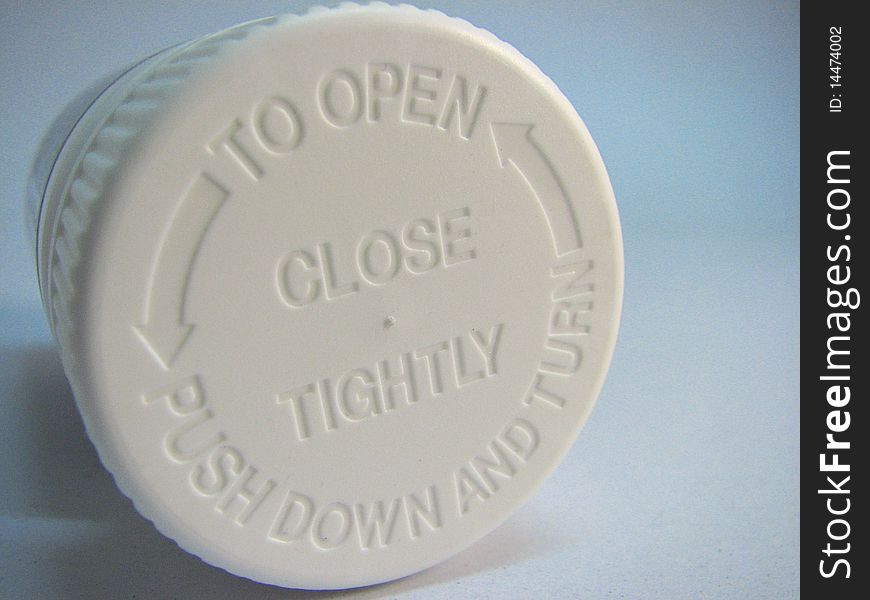 Instruction on a child proof cap of a bottle of pills