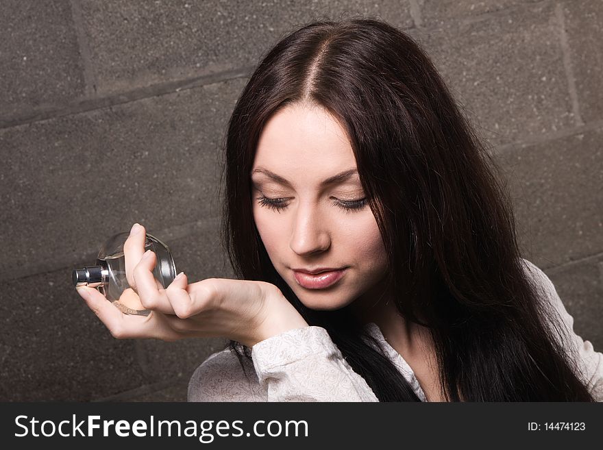 Beautiful lady with a bottle of perfume, face portrait