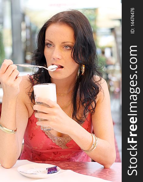 Young woman with black hair and some froth on a spoon. Young woman with black hair and some froth on a spoon