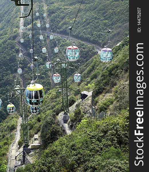 Over head cable cars hanging and running on the high mountain
