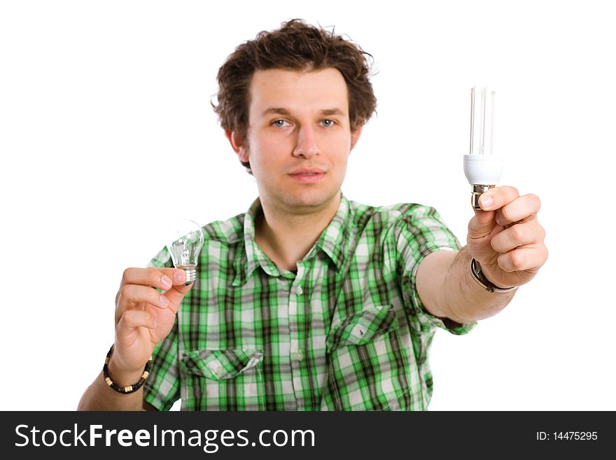 Young male adult holds two types of the lightbulbs, old style and new ecofriendly one, all isolated on white background. Young male adult holds two types of the lightbulbs, old style and new ecofriendly one, all isolated on white background