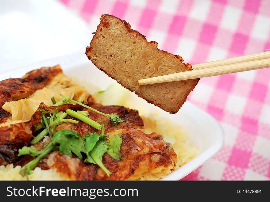 Chopsticks picking up roasted pork slice