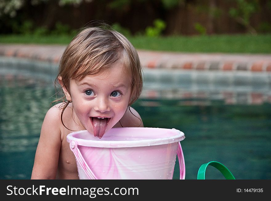 Little Girl Playing with Bucket by Pool. Little Girl Playing with Bucket by Pool