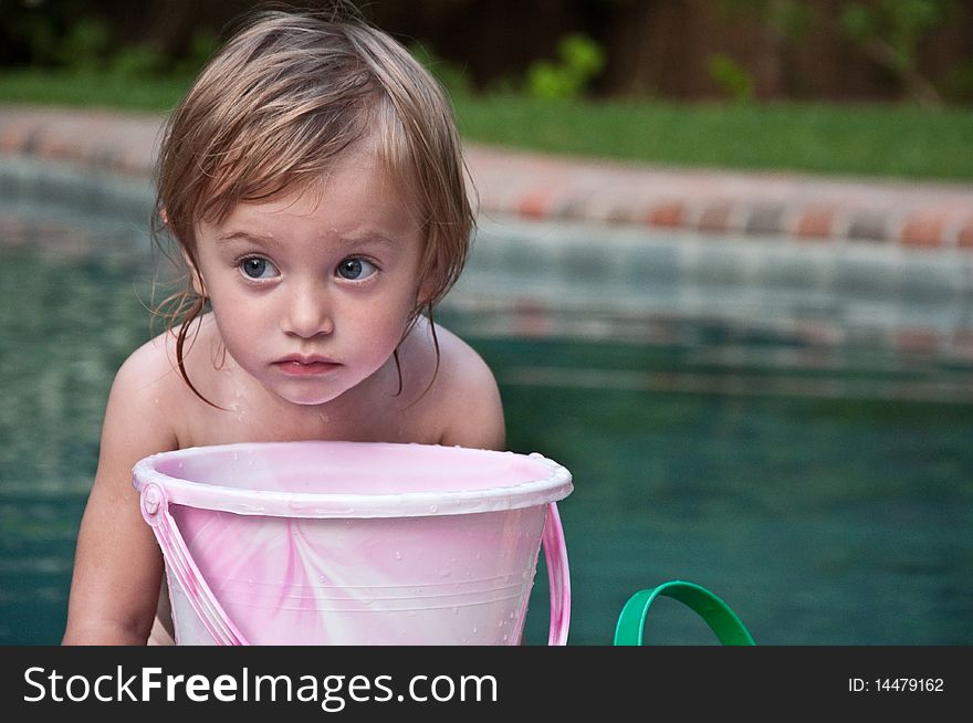 Little Girl Pondering with Bucket by Pool. Little Girl Pondering with Bucket by Pool