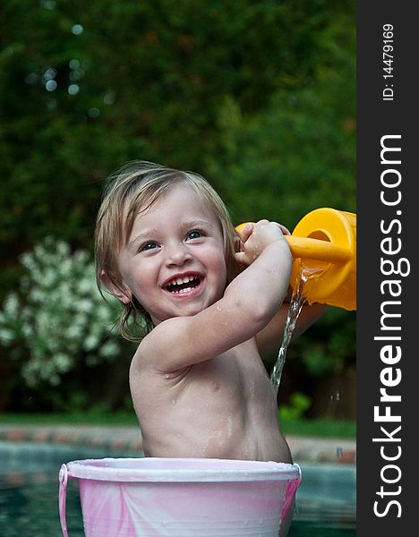 Little Girl Showering with Bucket by Pool. Little Girl Showering with Bucket by Pool
