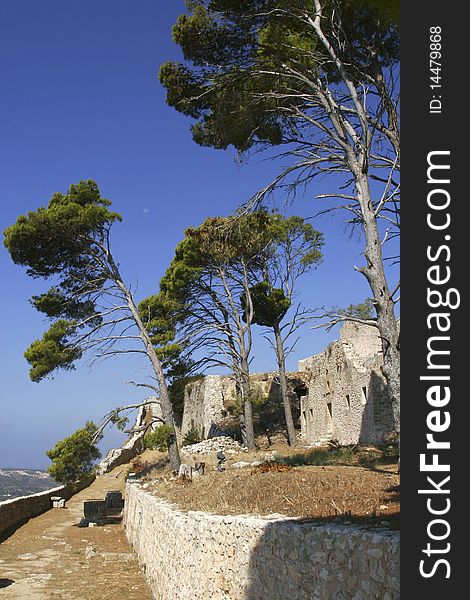 Portrait view of outer walls of the Saint Geroge's Castle featuring trees with deep blue sky. Portrait view of outer walls of the Saint Geroge's Castle featuring trees with deep blue sky