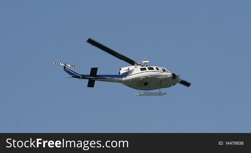 The helicopter flying on the dark blue sky