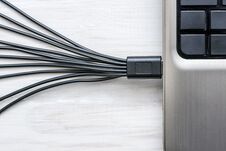 Black USB Cables Connected To Laptop On White Wooden Background Stock Photo