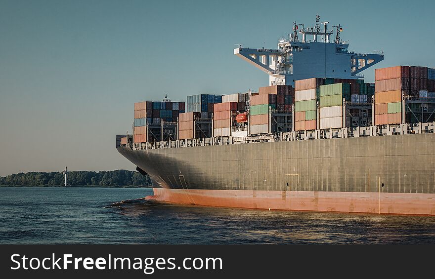 Container ship on the River Elbe at sunset.