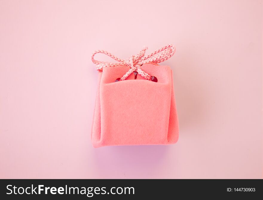 Closeup Of A Small Gift Wrapped With Pink Ribbon. Small Gift Box. Shallow Depth Of Field. Flat Lay, Top View.