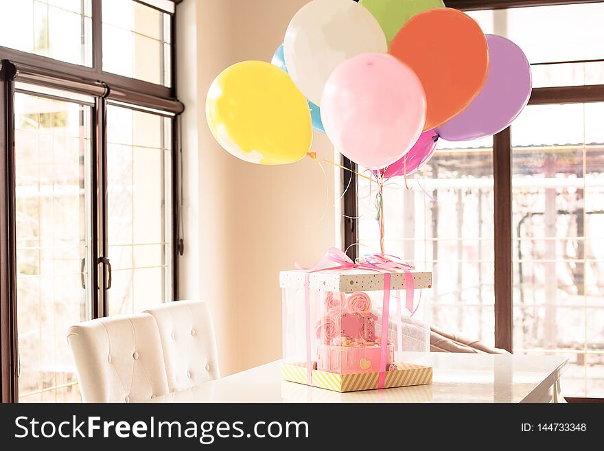 pink cake at the celebration of the first birthday of the girl, balloons  and congratulations, 1 year
