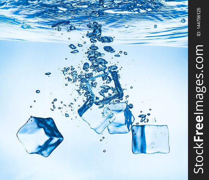 Ice cubes falling into the water sinking to the bottom. Abstract background. Ice cubes falling into the water sinking to the bottom. Abstract background