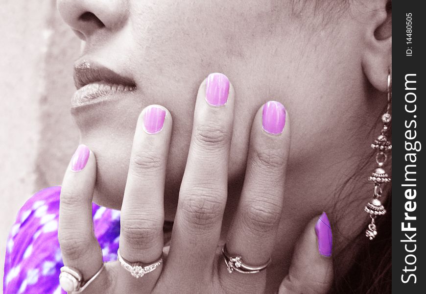 A young woman with pink nail polish, matching to her dress. A young woman with pink nail polish, matching to her dress