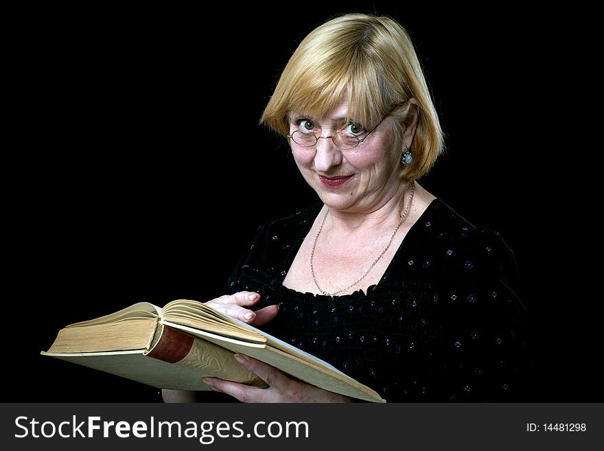 Happy senior woman with book and glasses on black
