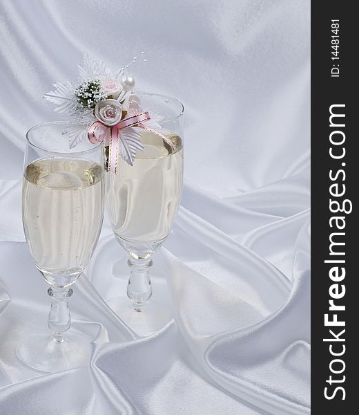 Glasses with champagne and weddings buttonholes on a dark background