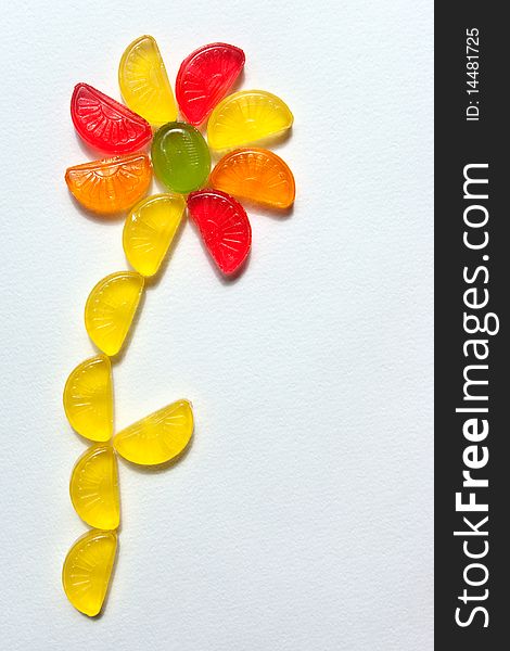 Funny flower combined from sugar candies on a white paper. Funny flower combined from sugar candies on a white paper