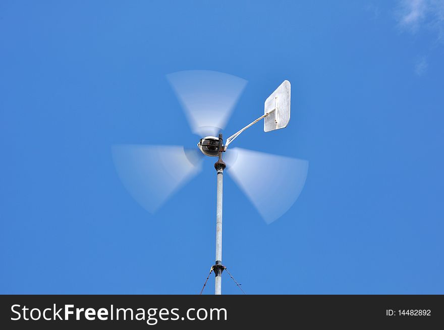 Running wind wheel against blue sky.