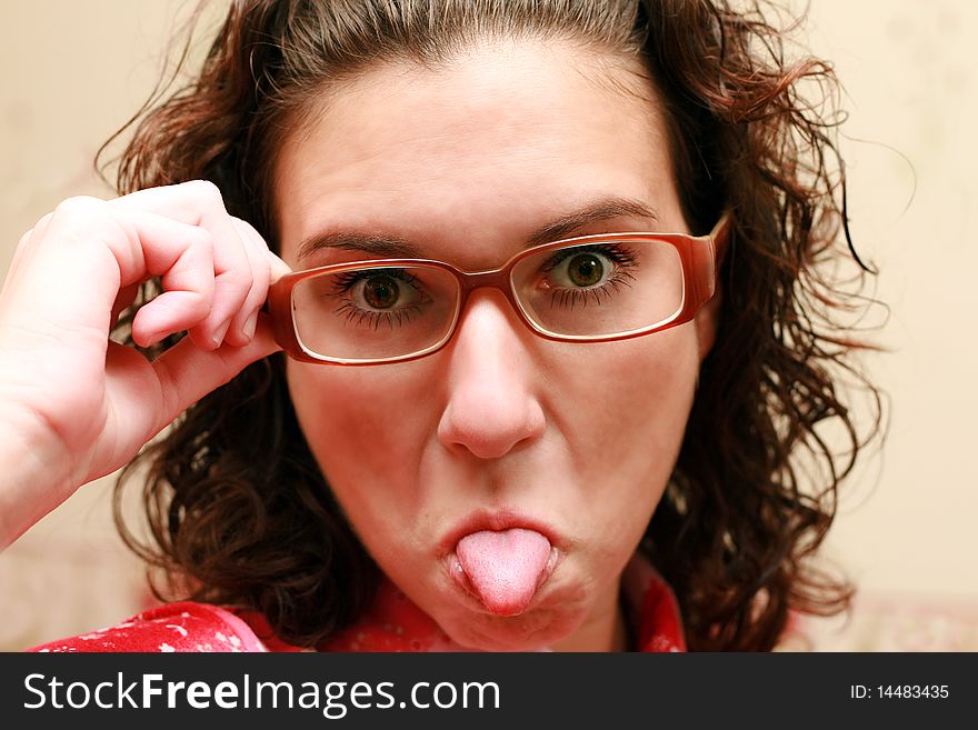 Woman in glasses  showing tongue. Woman in glasses  showing tongue