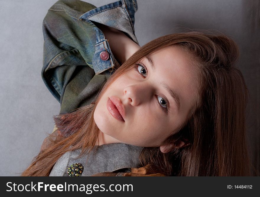 A portrait of a teenage model's face as she poses in a jean jacket. A portrait of a teenage model's face as she poses in a jean jacket