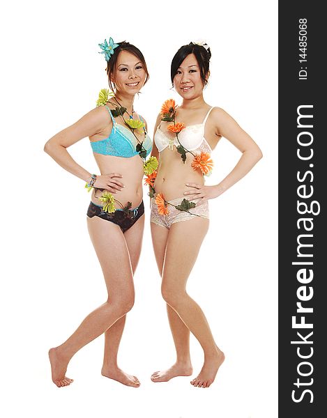 Two beautiful Asian woman in lingerie and nice flowers around there bodies, standing bare feet in the studio for white background. Two beautiful Asian woman in lingerie and nice flowers around there bodies, standing bare feet in the studio for white background.