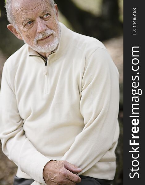 Portrait of  a Senior Man Sitting Outdoors Looking Away from Camera. Portrait of  a Senior Man Sitting Outdoors Looking Away from Camera