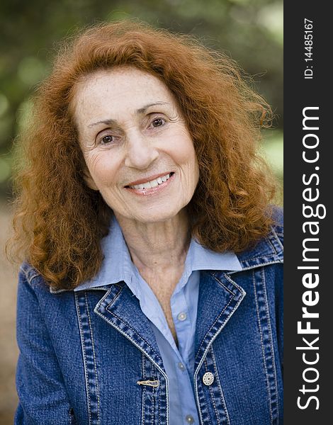 Portrait of an Attractive Redhead Senior Woman in a Denim Jacket. Portrait of an Attractive Redhead Senior Woman in a Denim Jacket